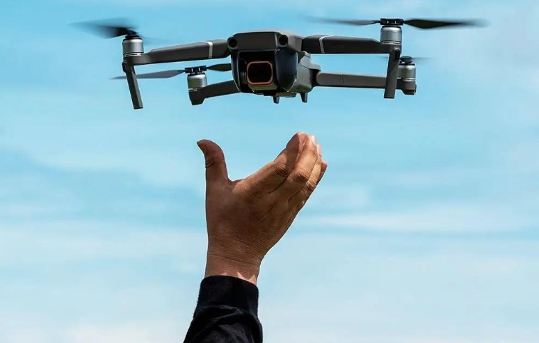 Drone launching from hand against a blue sky